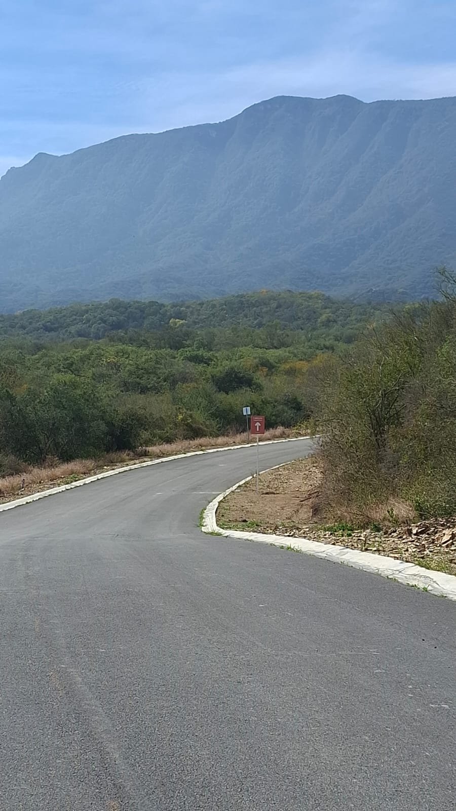 Acceso pavimentado con vista a la montaña